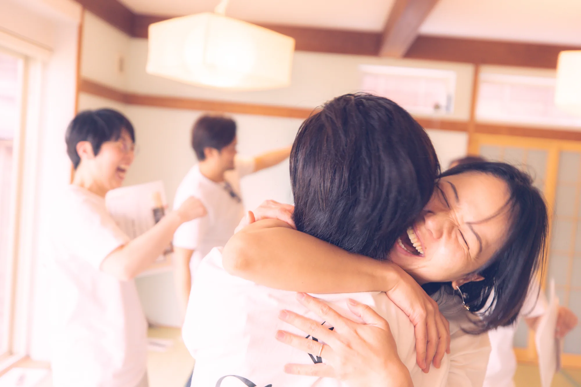 Two women embracing and laughing after a GIVER® Kundalini Activation Astral Work session in Japan