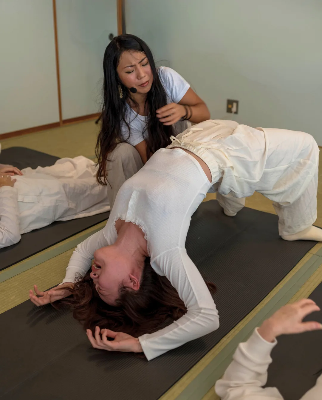 Facilitator supporting a participant through a spontaneous backbend during a GIVER® Kundalini Activation Astral Work session in Japan