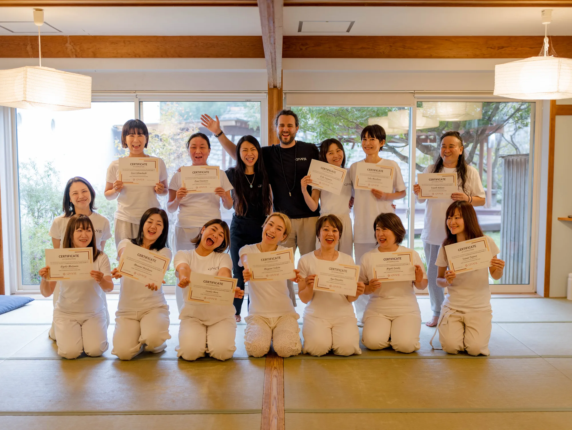 2025 GIVER® facilitator training graduates with certificates in a tatami-floored training room in Japan