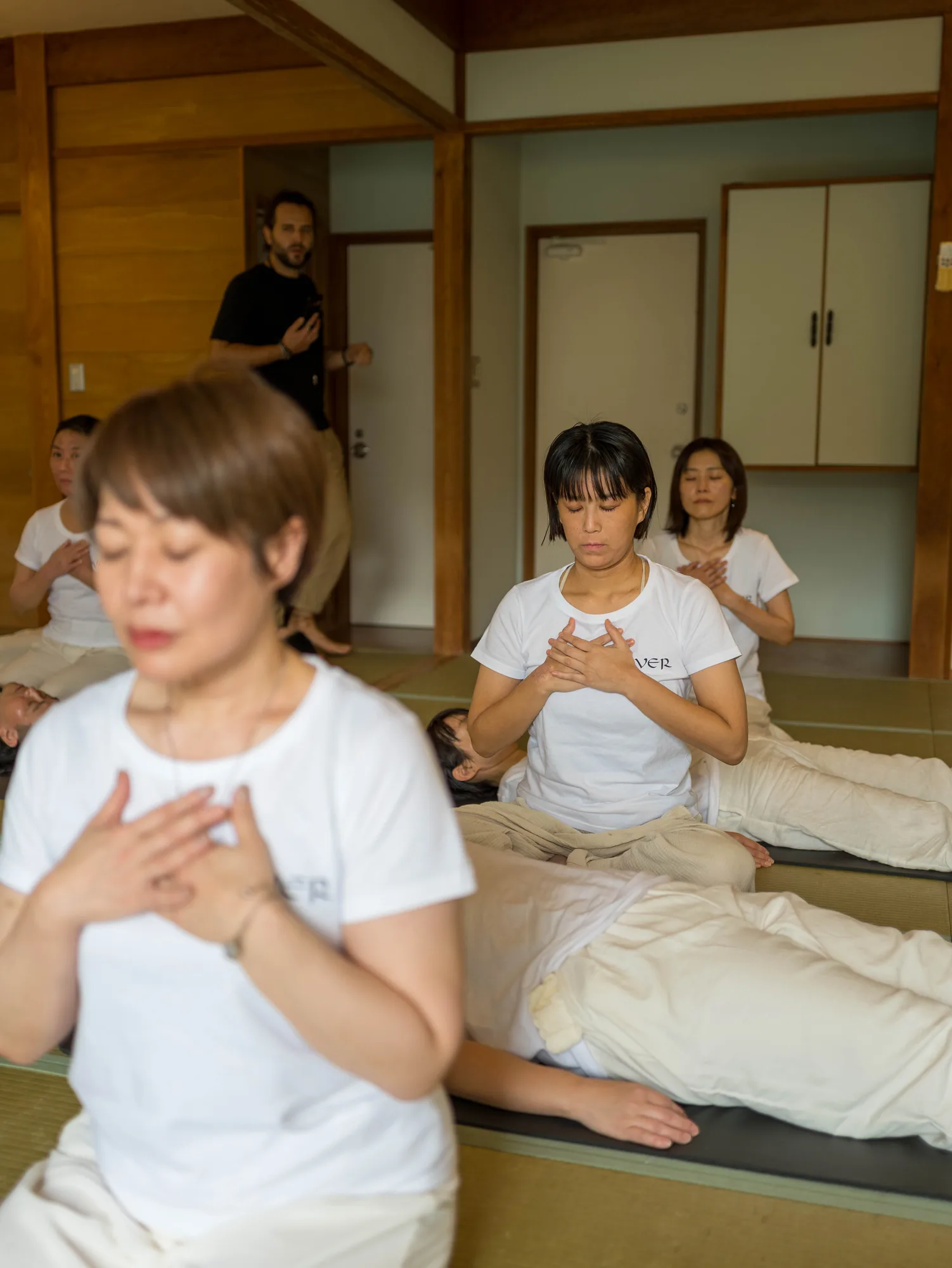 Participants with hands on heart during a GIVER® Kundalini Activation Astral Work session in Japan