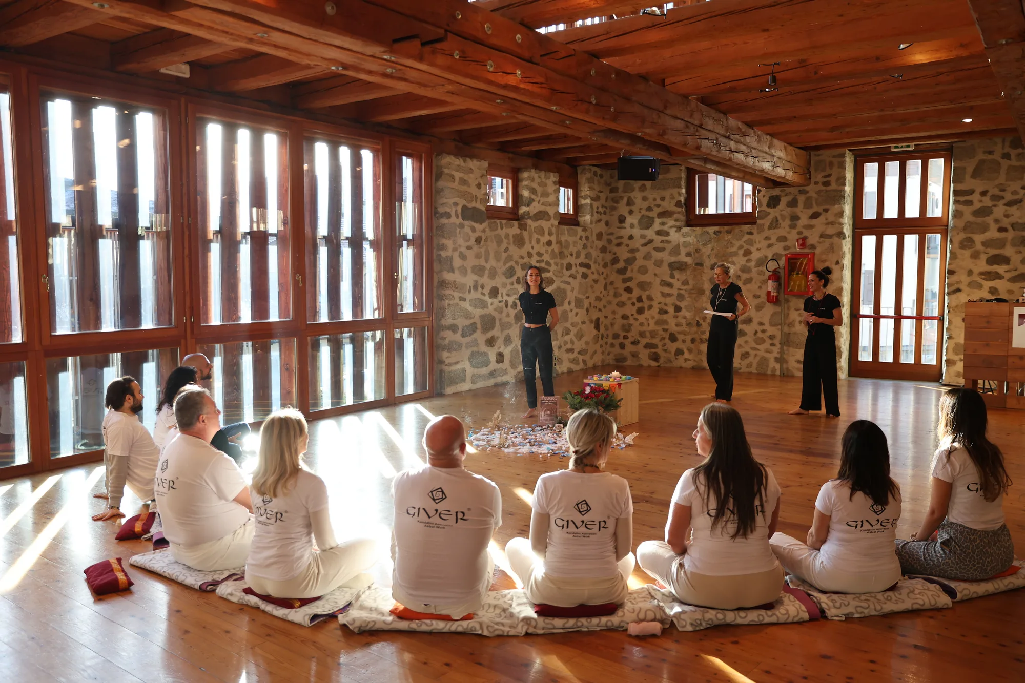 Opening circle in a stone hall during the GIVER® Kundalini Activation Astral Work training in Italy