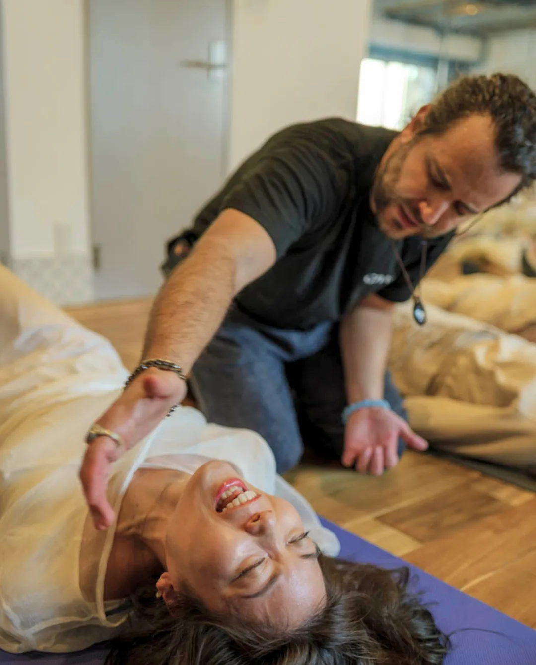 GIVER® facilitator working with a participant lying on a mat during a Kundalini Activation Astral Work session in Japan