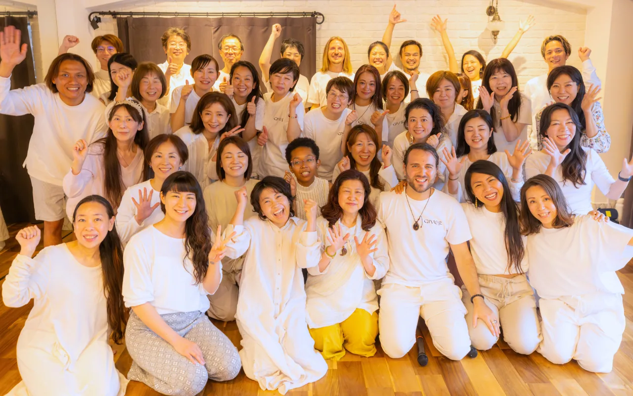 Large group with hands raised after a GIVER® Kundalini Activation Astral Work session in Japan