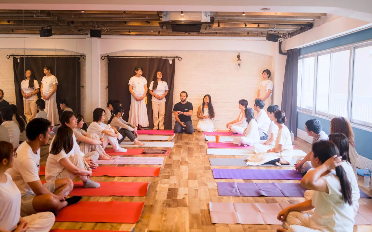 GIVER® facilitators opening a Kundalini Activation Astral Work session with a seated circle of participants in Japan