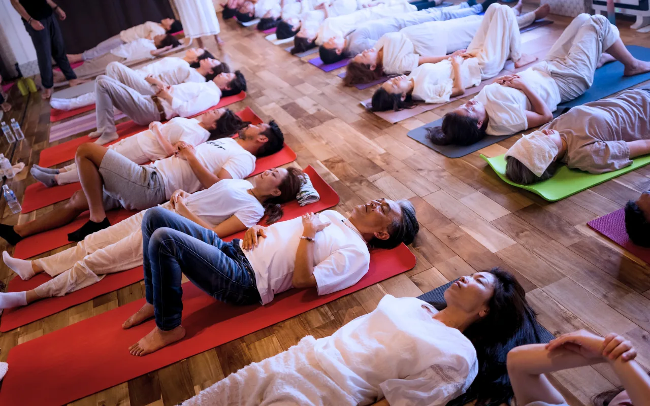 Participants lying on coloured mats during a GIVER® Kundalini Activation Astral Work session in Japan