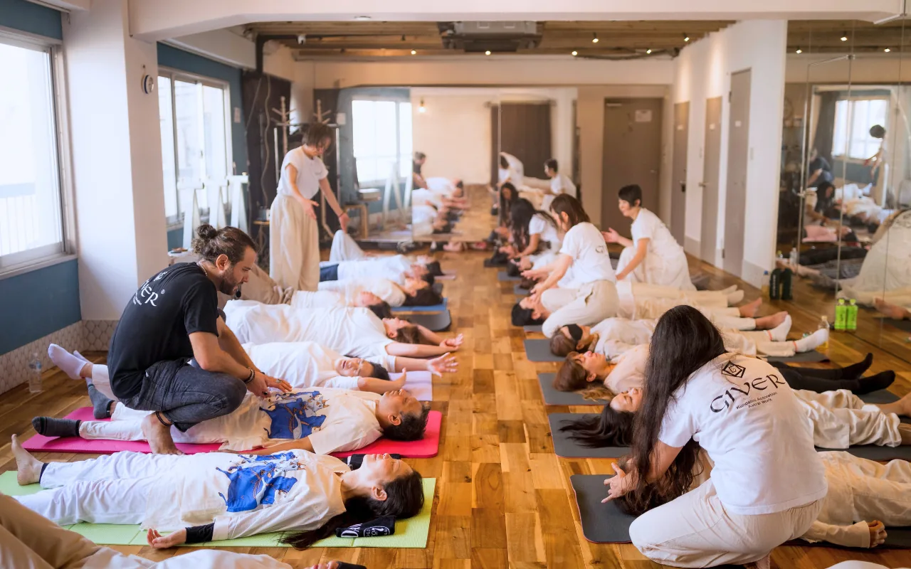 GIVER® facilitators working with participants lying on mats during a Kundalini Activation Astral Work session in Japan
