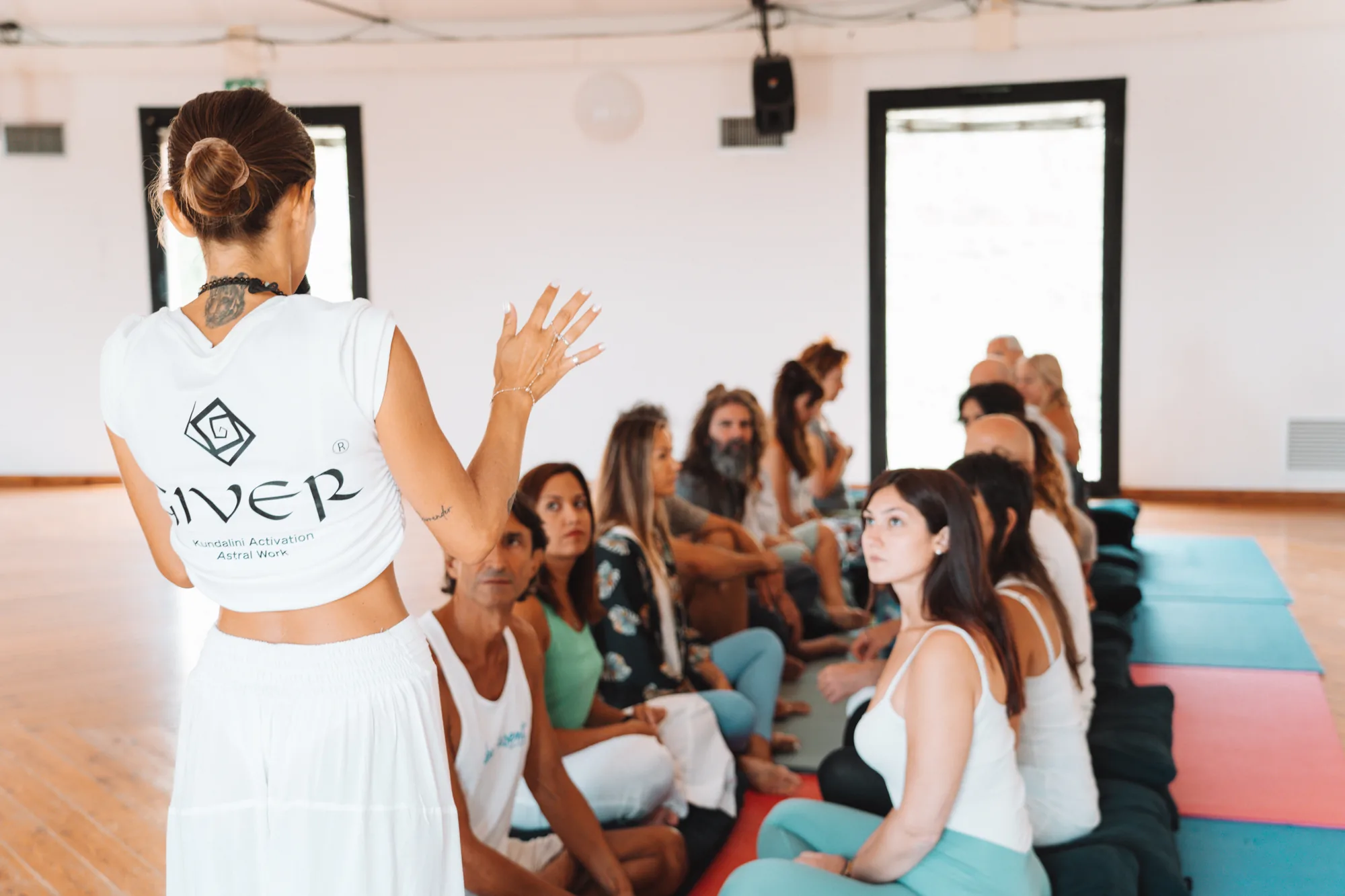 GIVER® facilitator in a teaching a seated group during Kundalini Activation Astral Work facilitator training